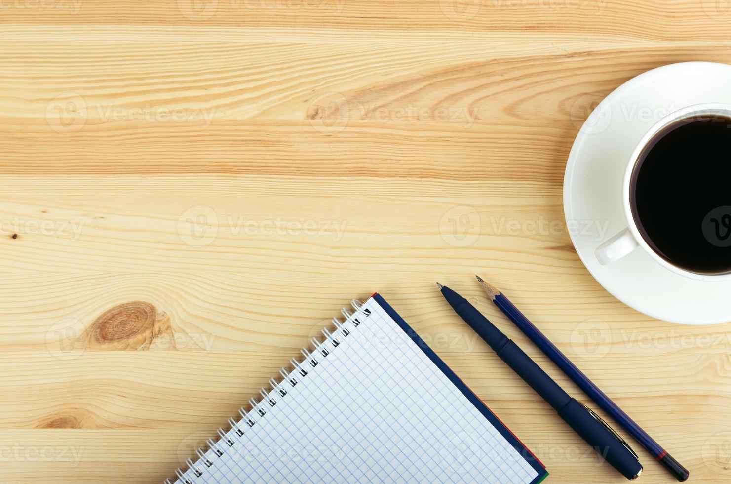 anteckningsbok penna och kopp kaffe i träbord foto
