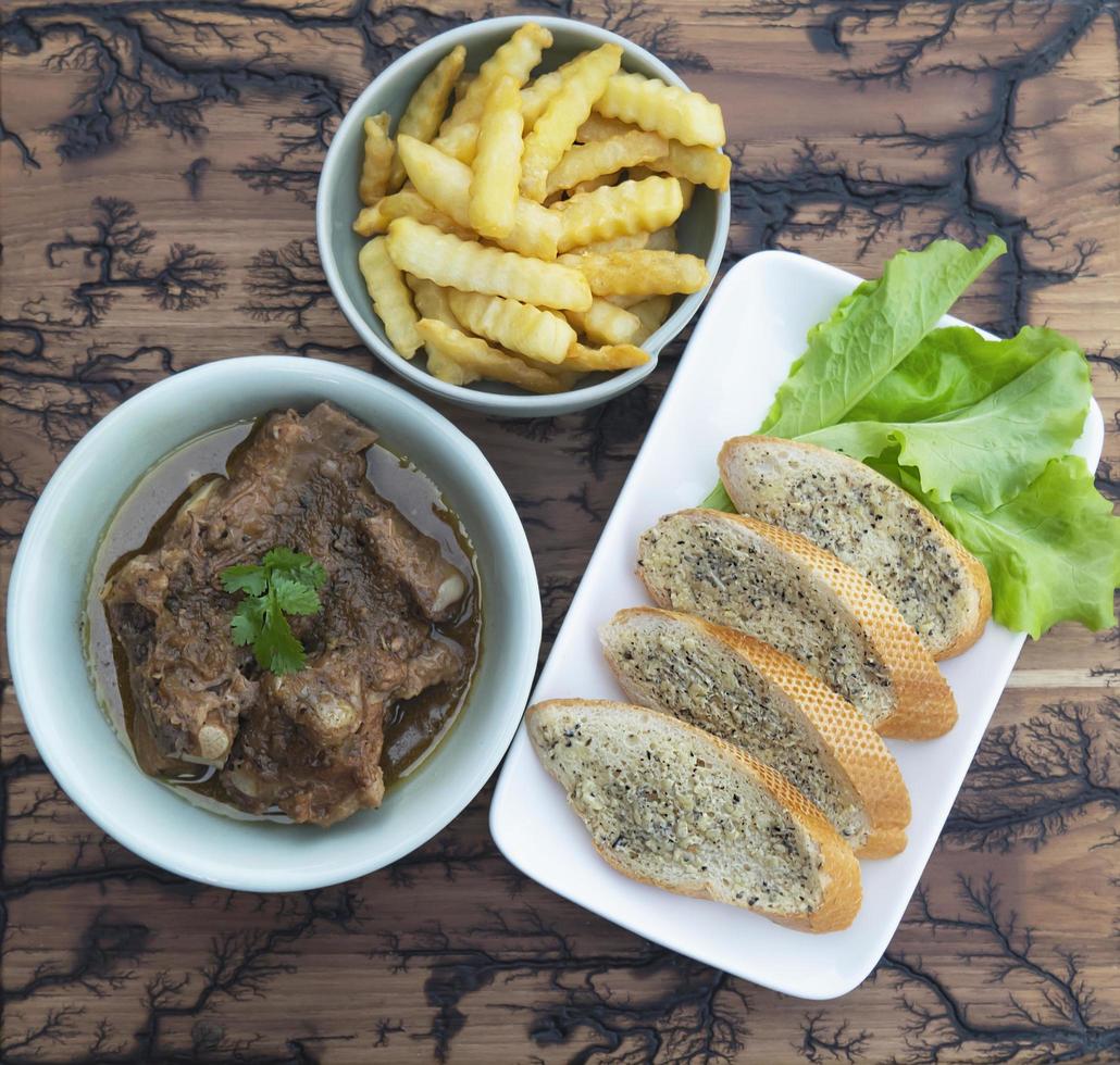 fläskgryta servera med pommes frites och vitlöksbröd foto