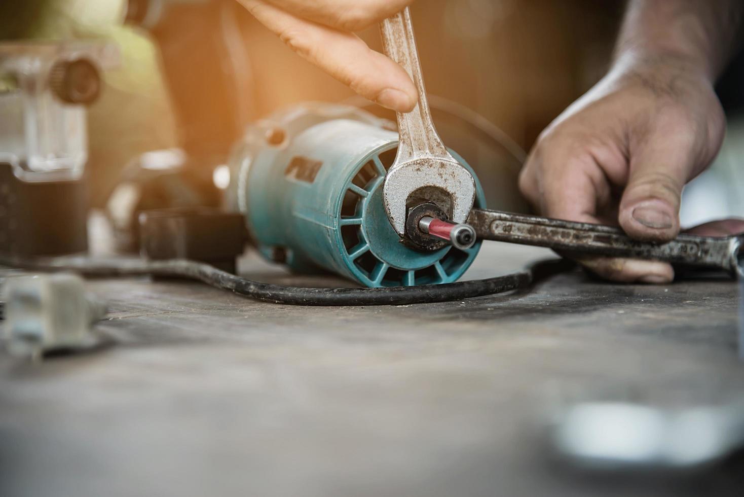 man förbereder elektrisk överfräs laminattrimmer verktygsmaskin - snickarverkstadskoncept foto