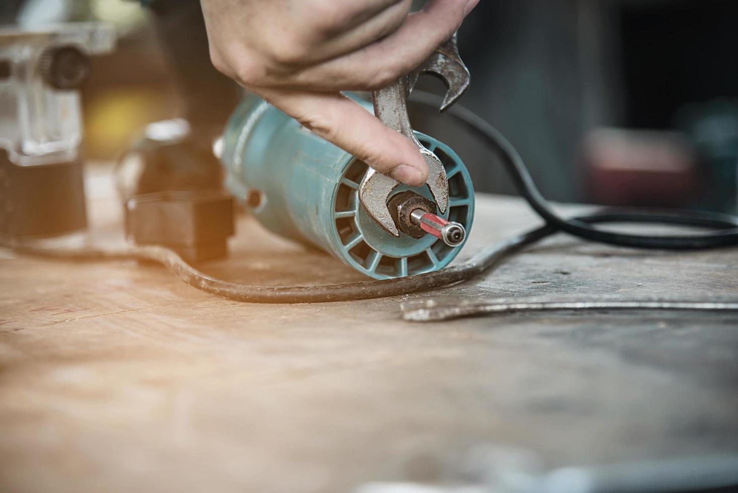 man förbereder elektrisk överfräs laminattrimmer verktygsmaskin - snickarverkstadskoncept foto