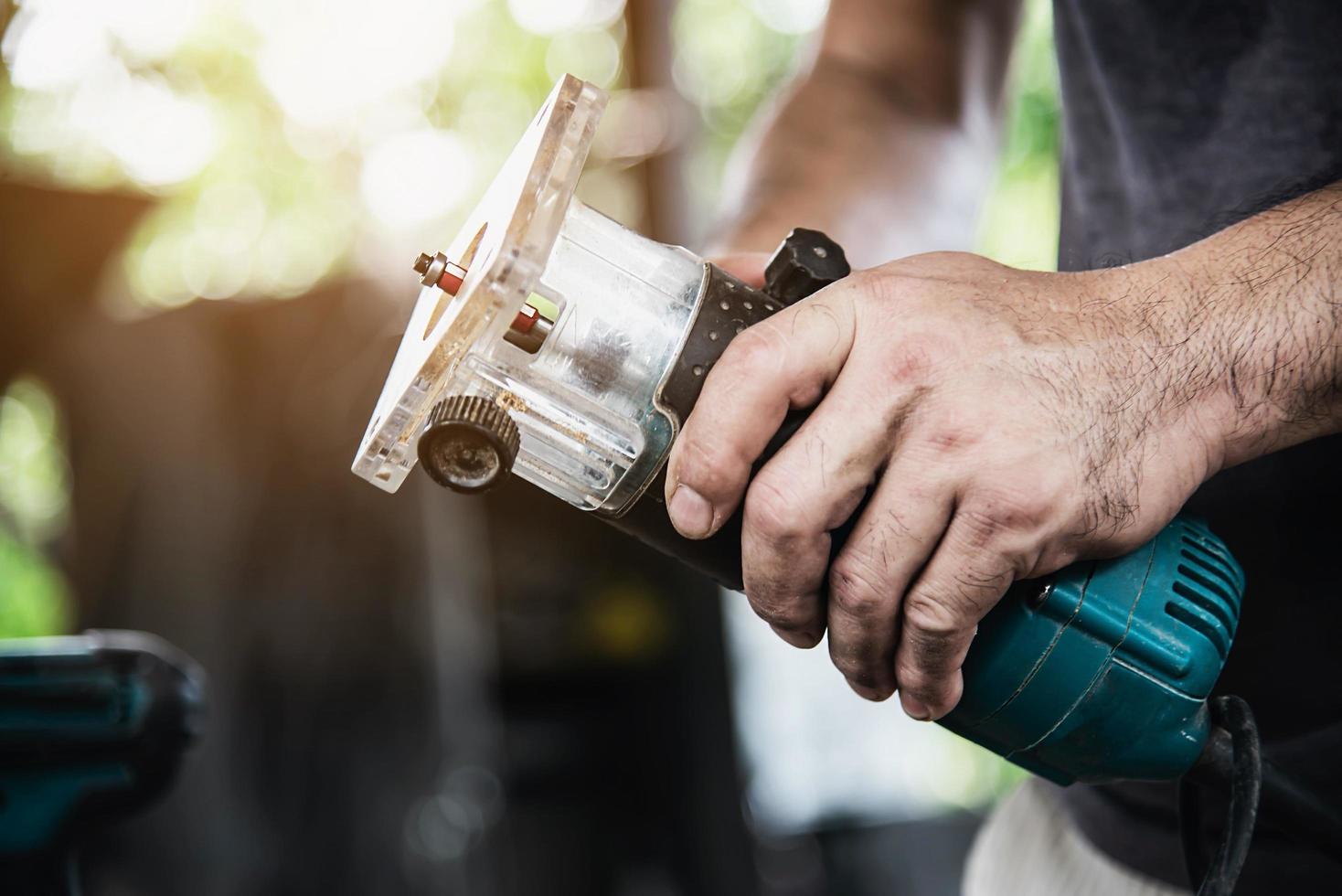 man förbereder elektrisk överfräs laminattrimmer verktygsmaskin - snickarverkstadskoncept foto