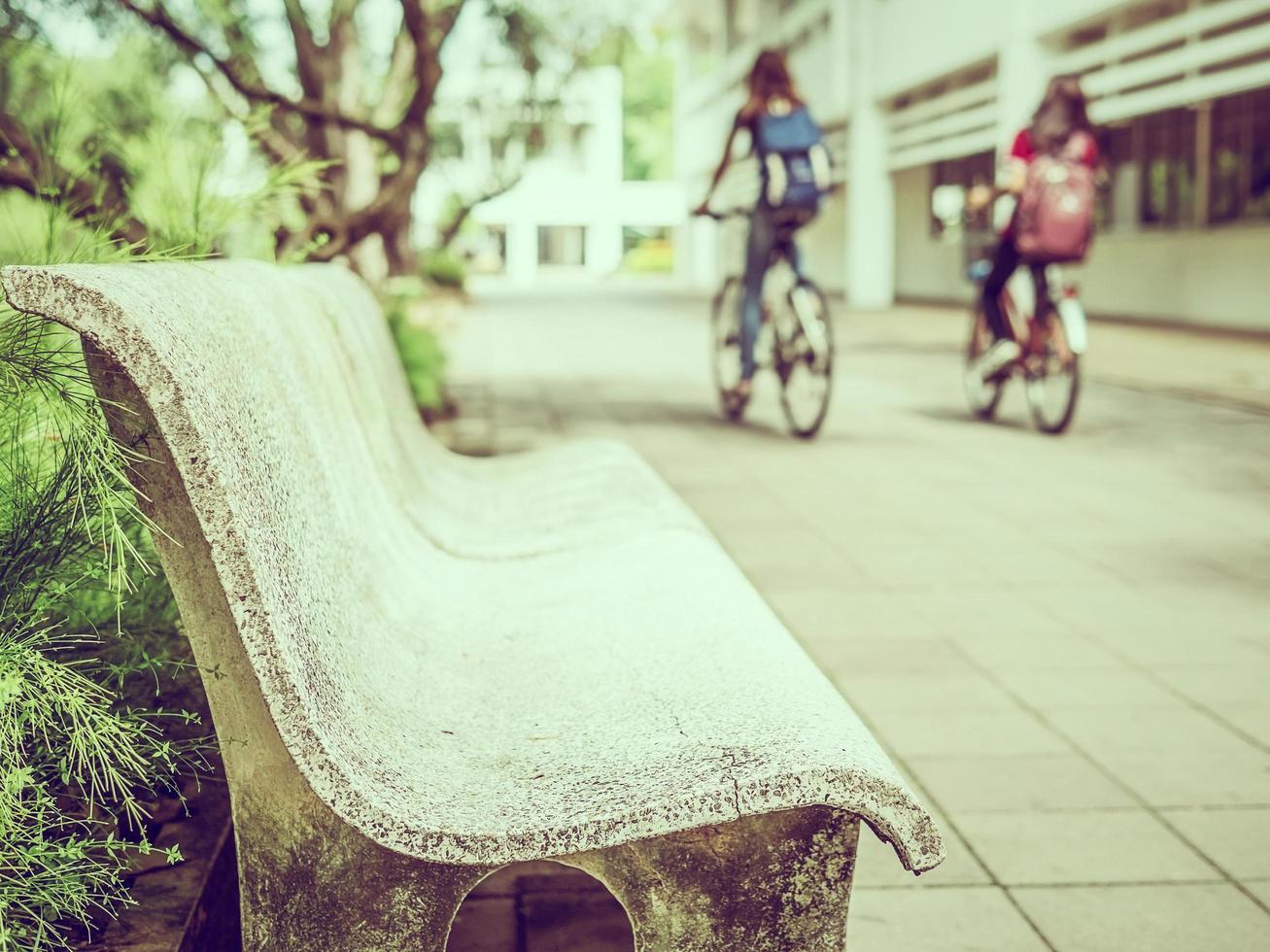 vintage stil foto av bänk sitter med suddig cykling student på campus