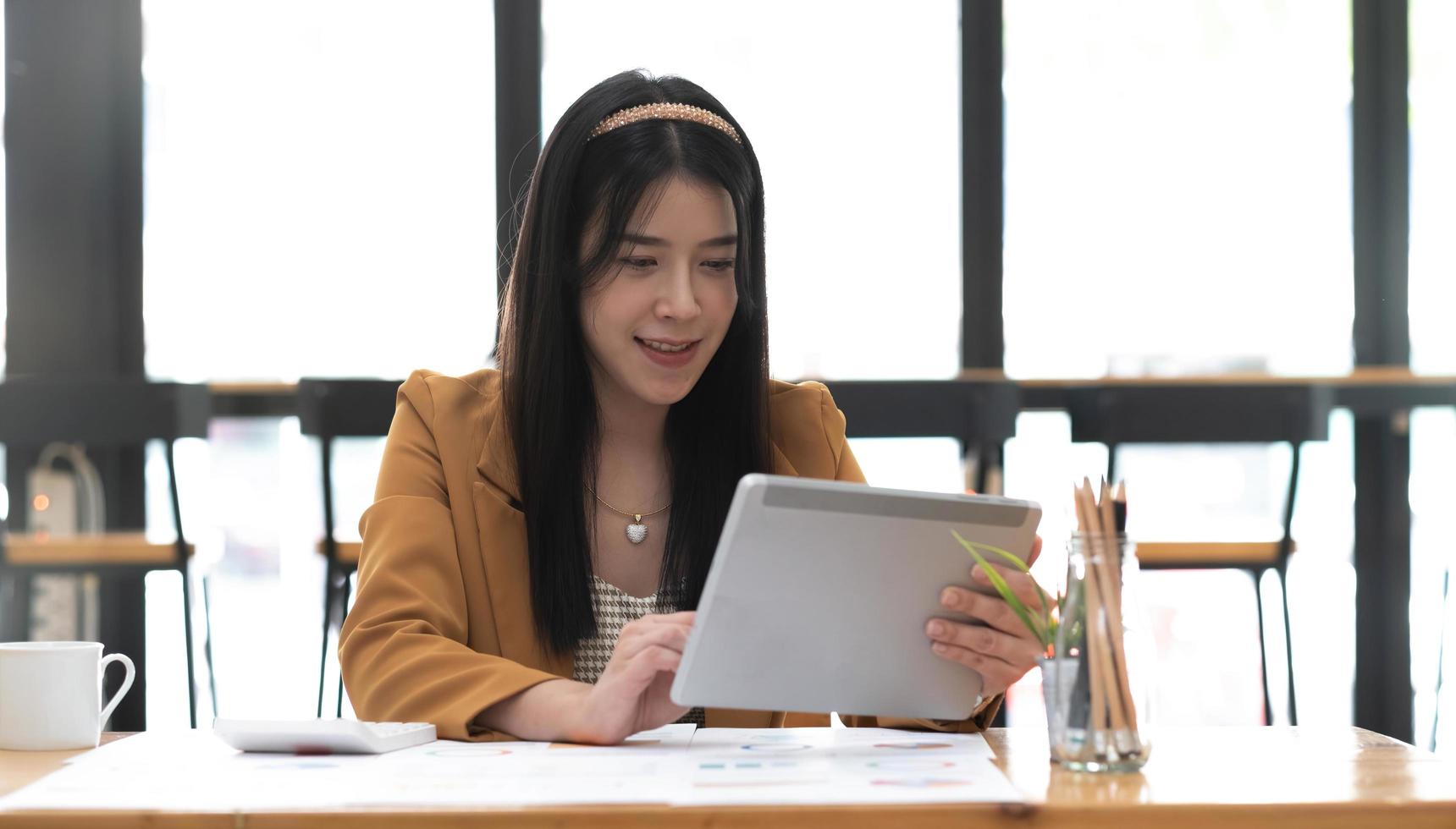 porträtt av ung asiatisk affärskvinna som använder digital surfplatta på kontoret. foto