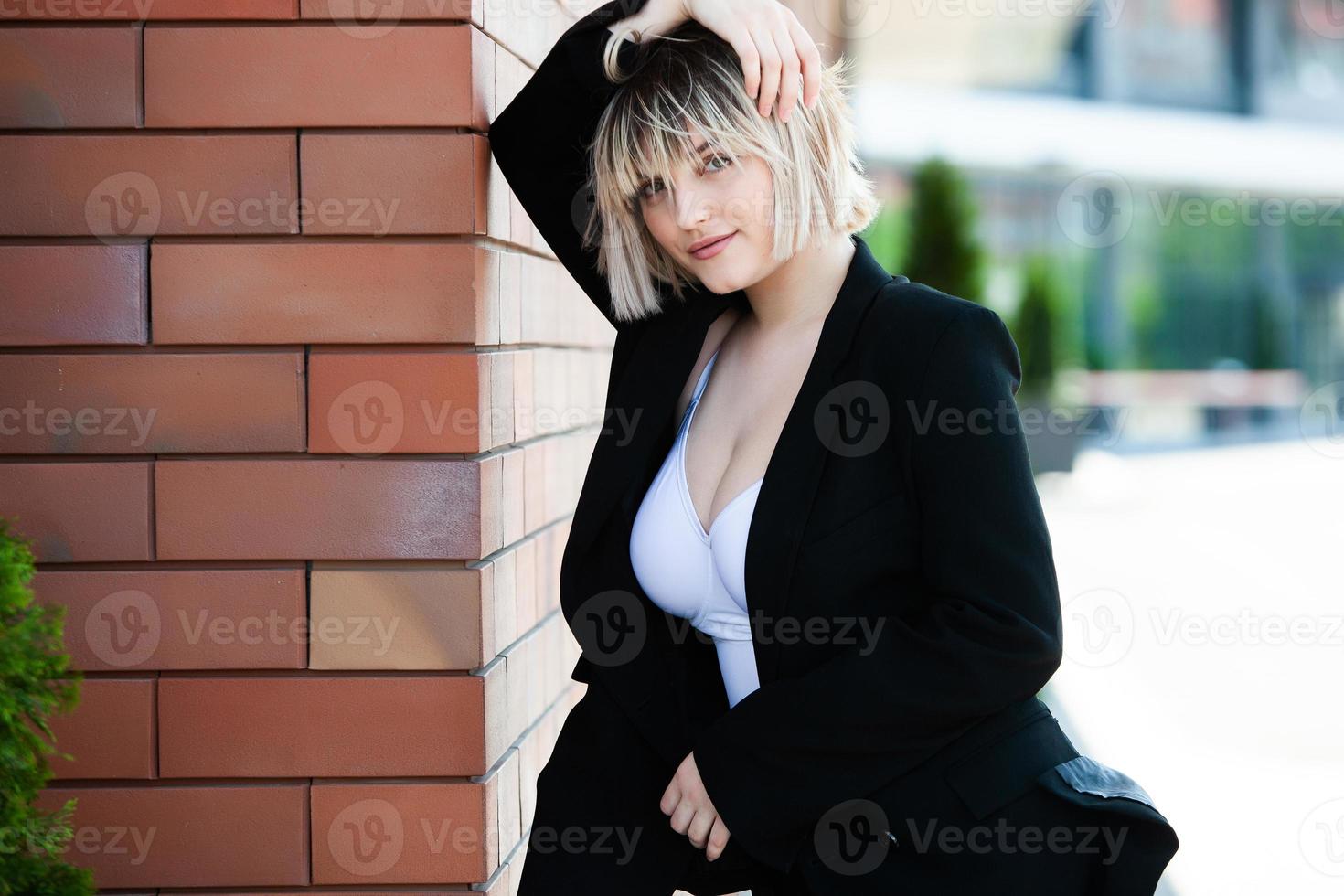 självsäker affärsexpert. glad framgångsrik professionell poserar nära kontorsbyggnad. europeisk tjej. rysk affärskvinna. kvinnligt företagsledare koncept. porträtt av framgångsrik affärskvinna foto
