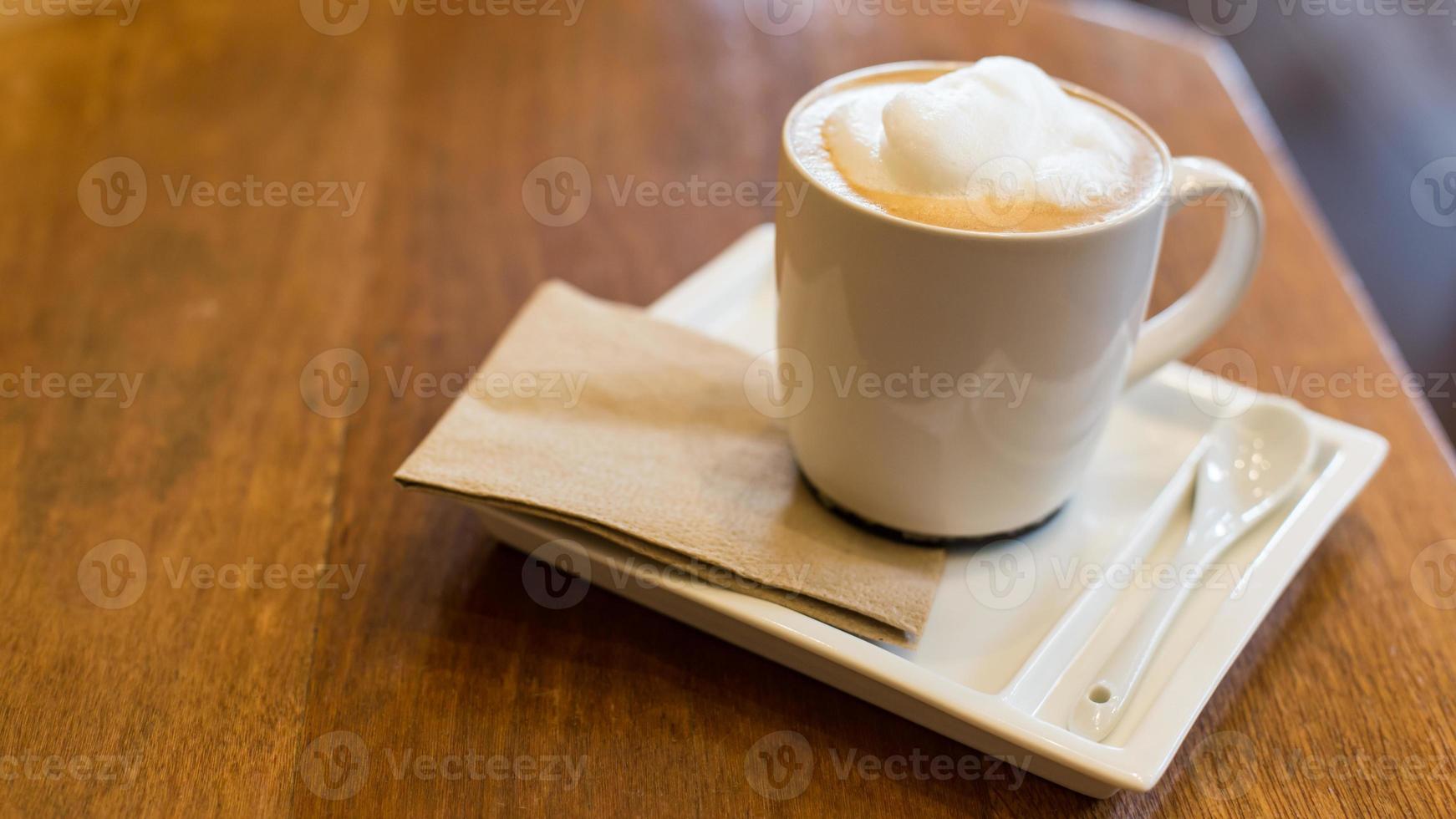 latte kaffe i en kopp på träbord. foto