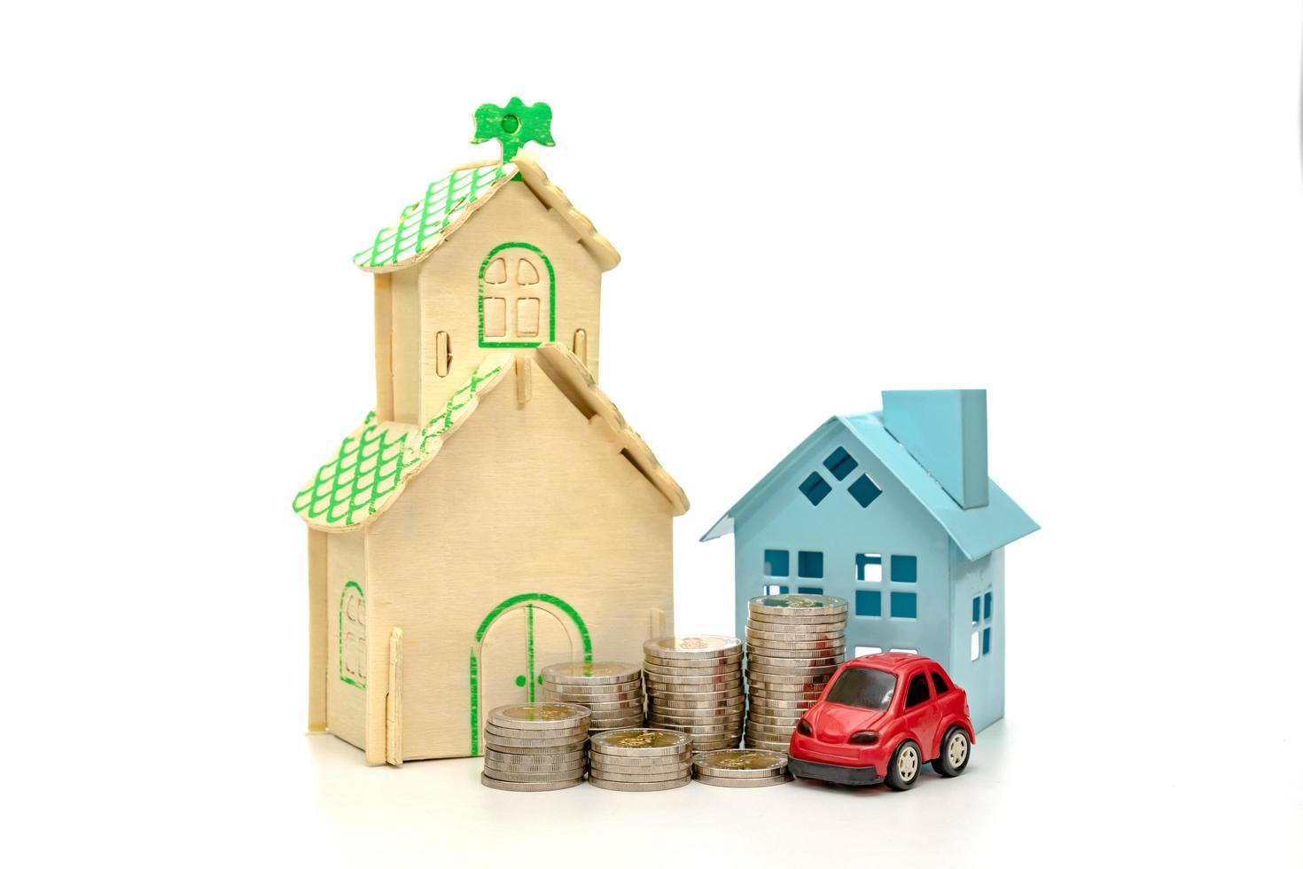 myntstaplar och bil och hus på vit bakgrund, affärssparande och investeringskoncept foto