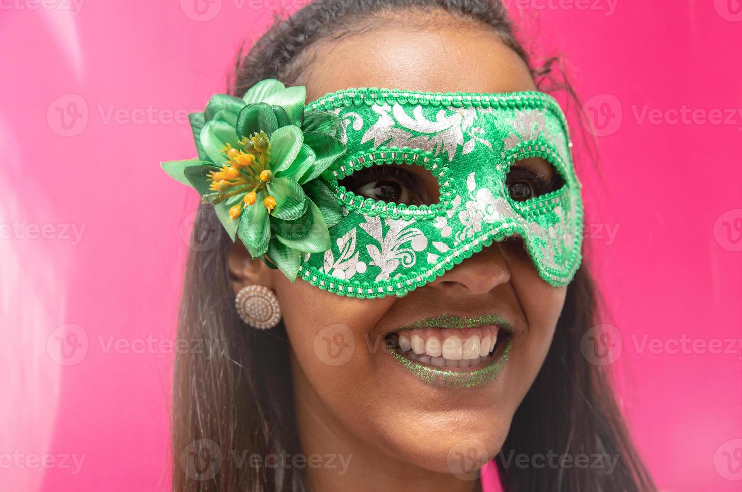 glad ung kvinna med mask och konfetti på karnevalsfest. brasiliansk karneval foto