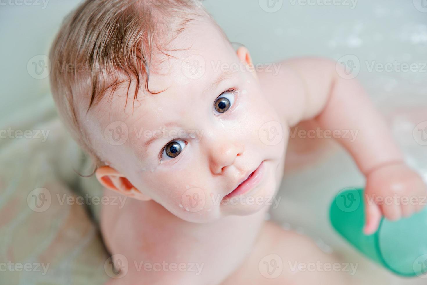 söt glad baby tar ett bad och leker foto