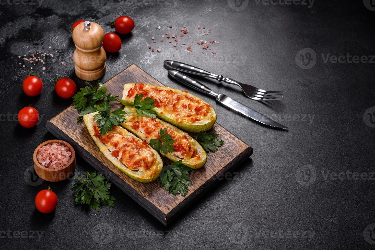 bakade fyllda zucchinibåtar med hackad kycklingsvamp och grönsaker med ost foto