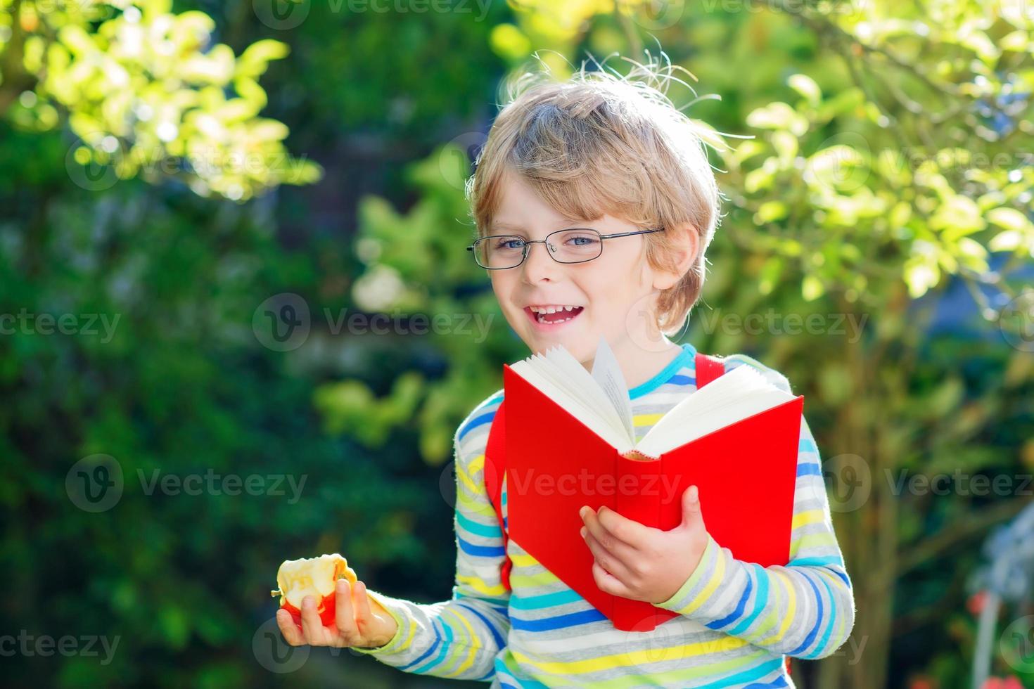 liten pojke med äpple på väg till skolan foto