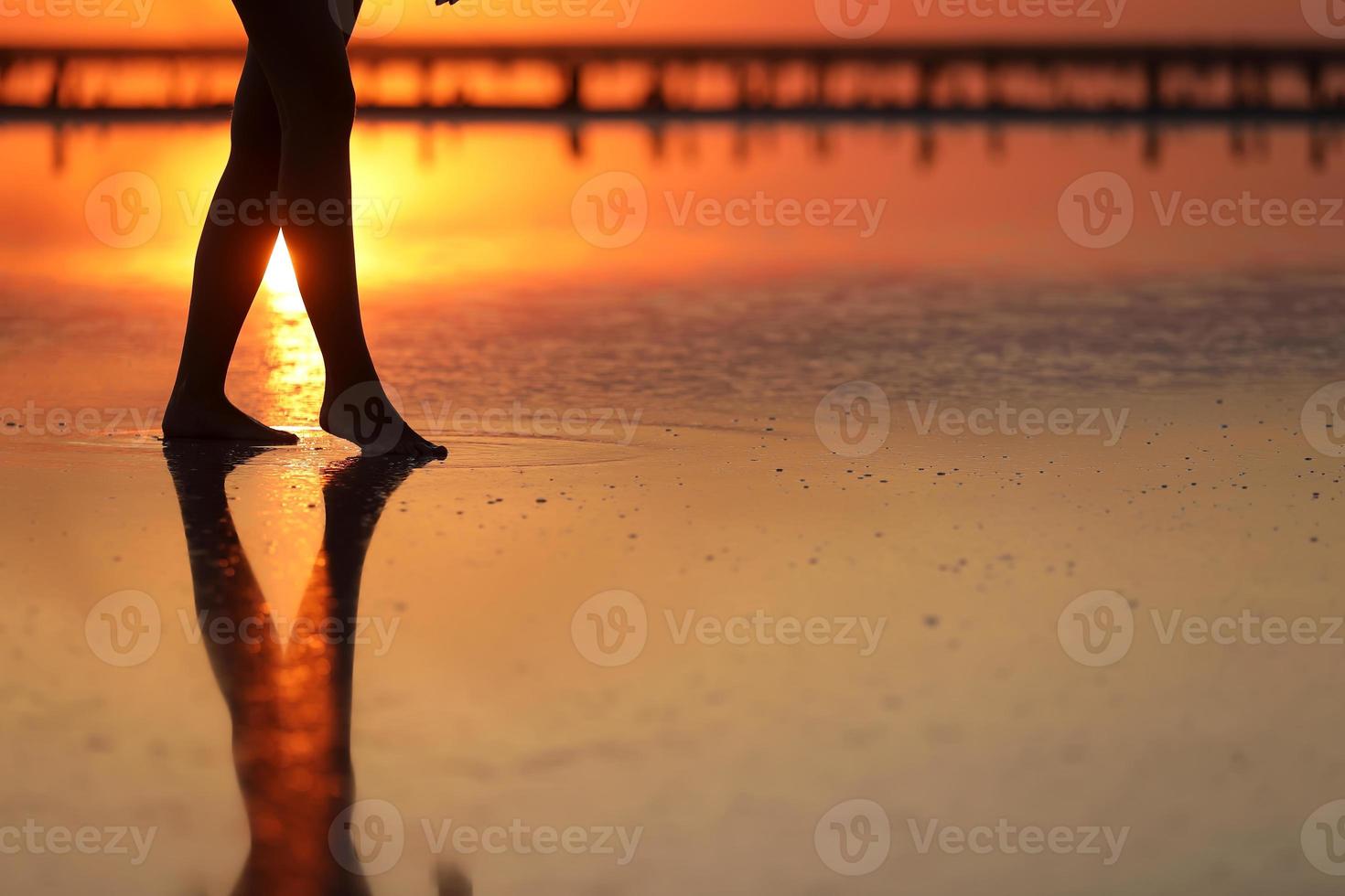 bilder från sidan av vacker ung kvinna i baddräkten som går på stranden mot havet. tjejen är väldigt smal foto