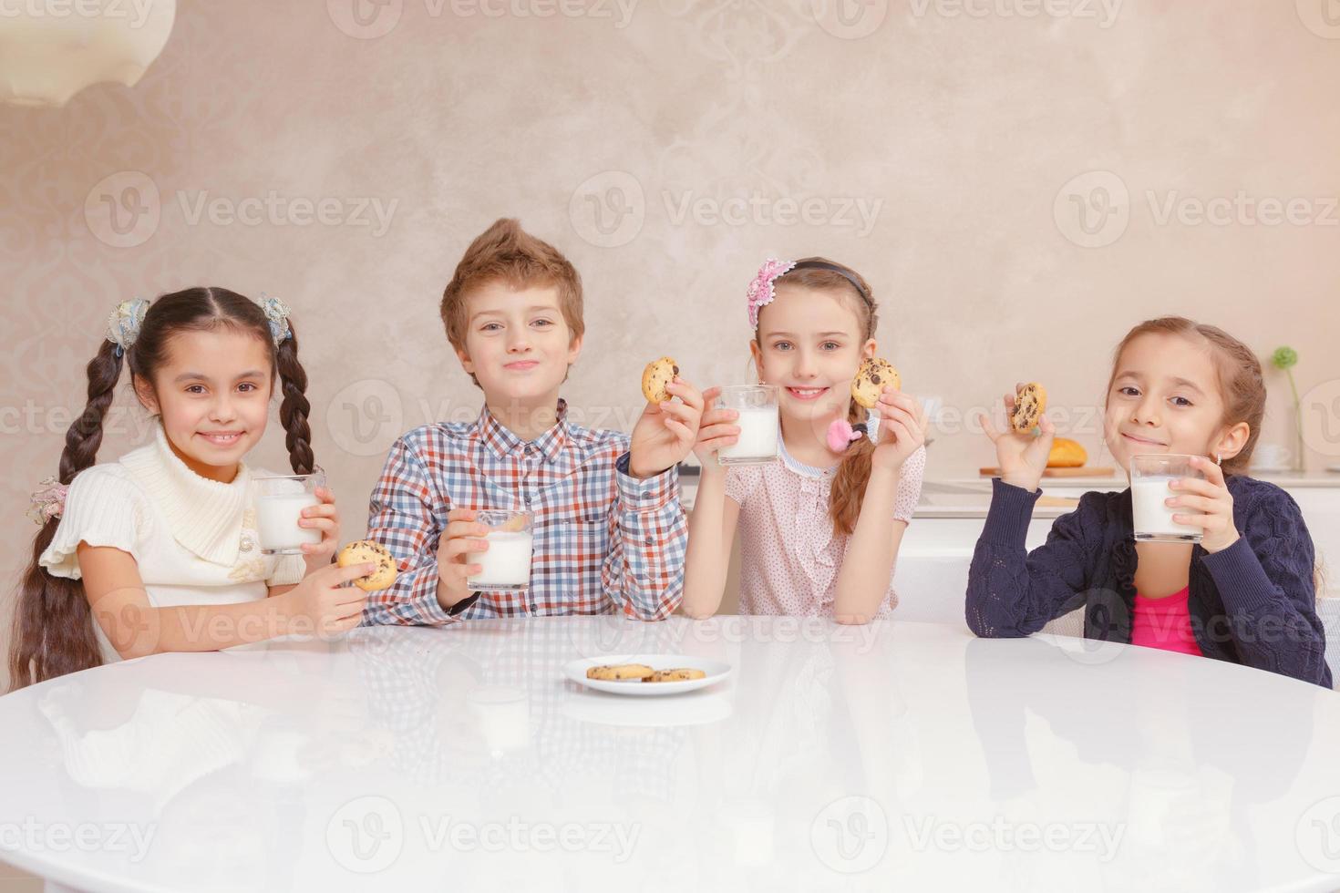 barn dricker mjölk med kakor foto