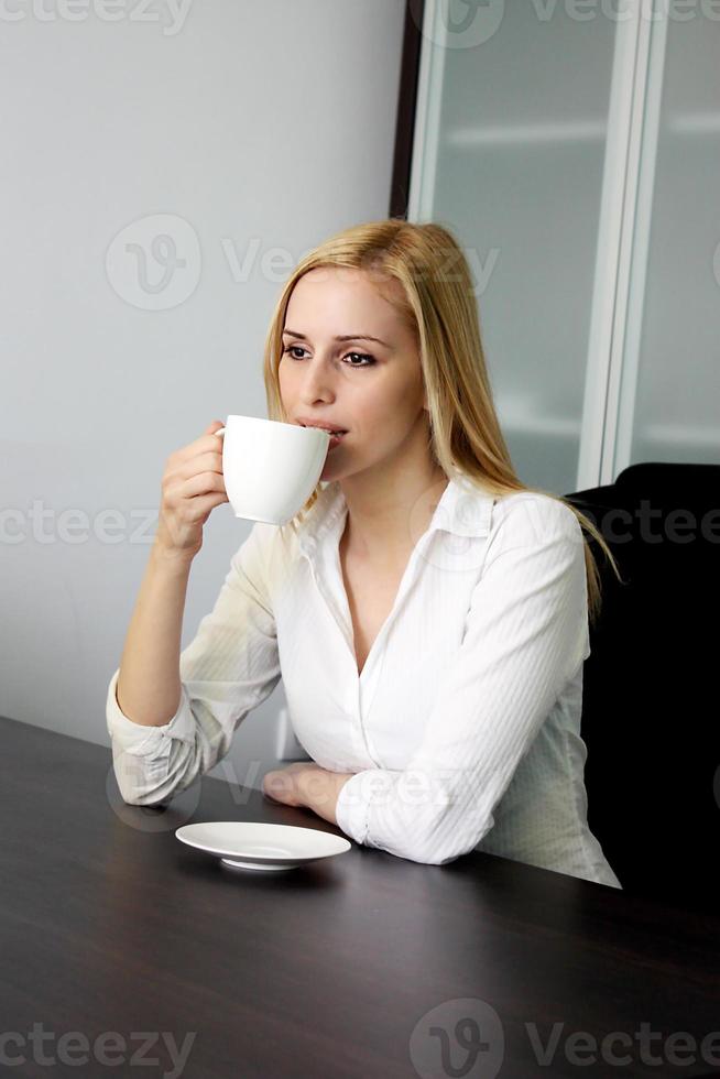dricker kaffe på kontoret foto