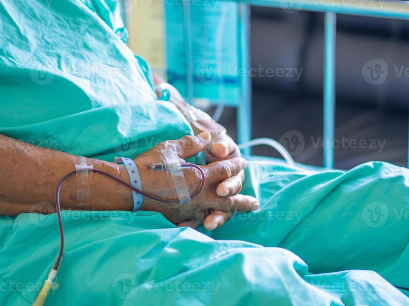 närbild hand av senior man patienten ger blod under behandla anemi i patienten foto