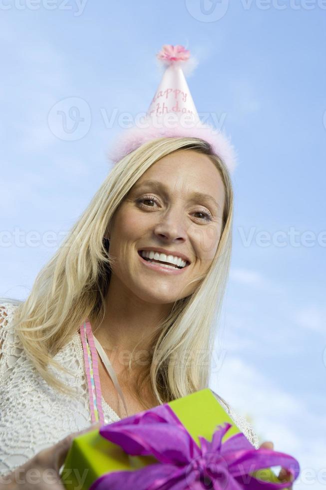 mitten av vuxen kvinna med födelsedagspresent foto