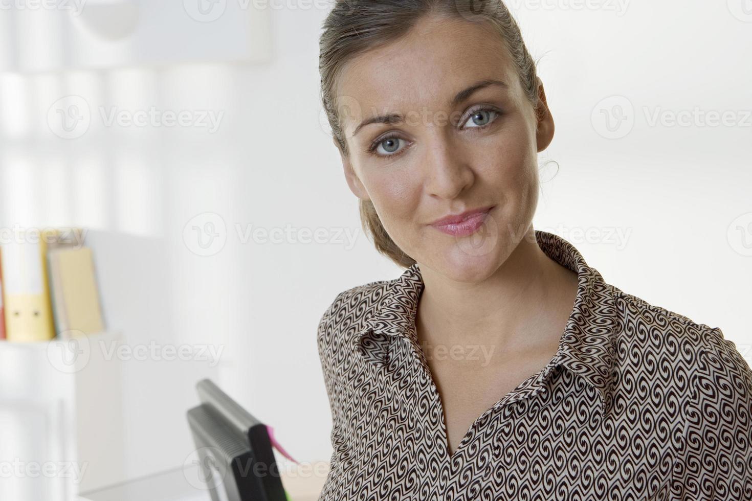 affärskvinna som står på kontoret, ler, närbild, porträtt foto