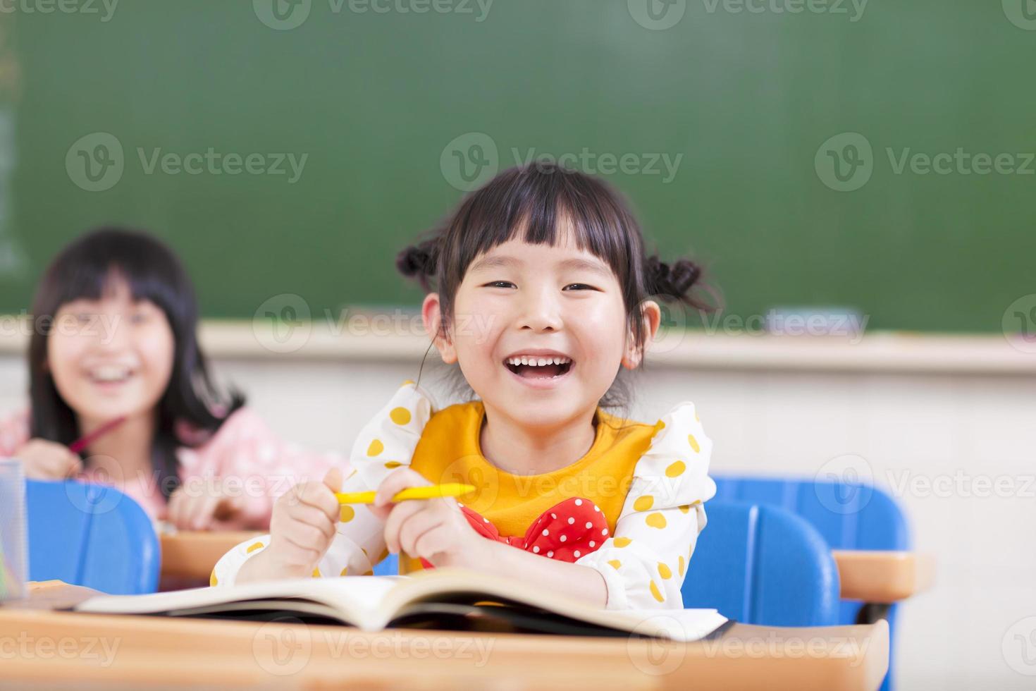glada barn som studerar i ett klassrum foto