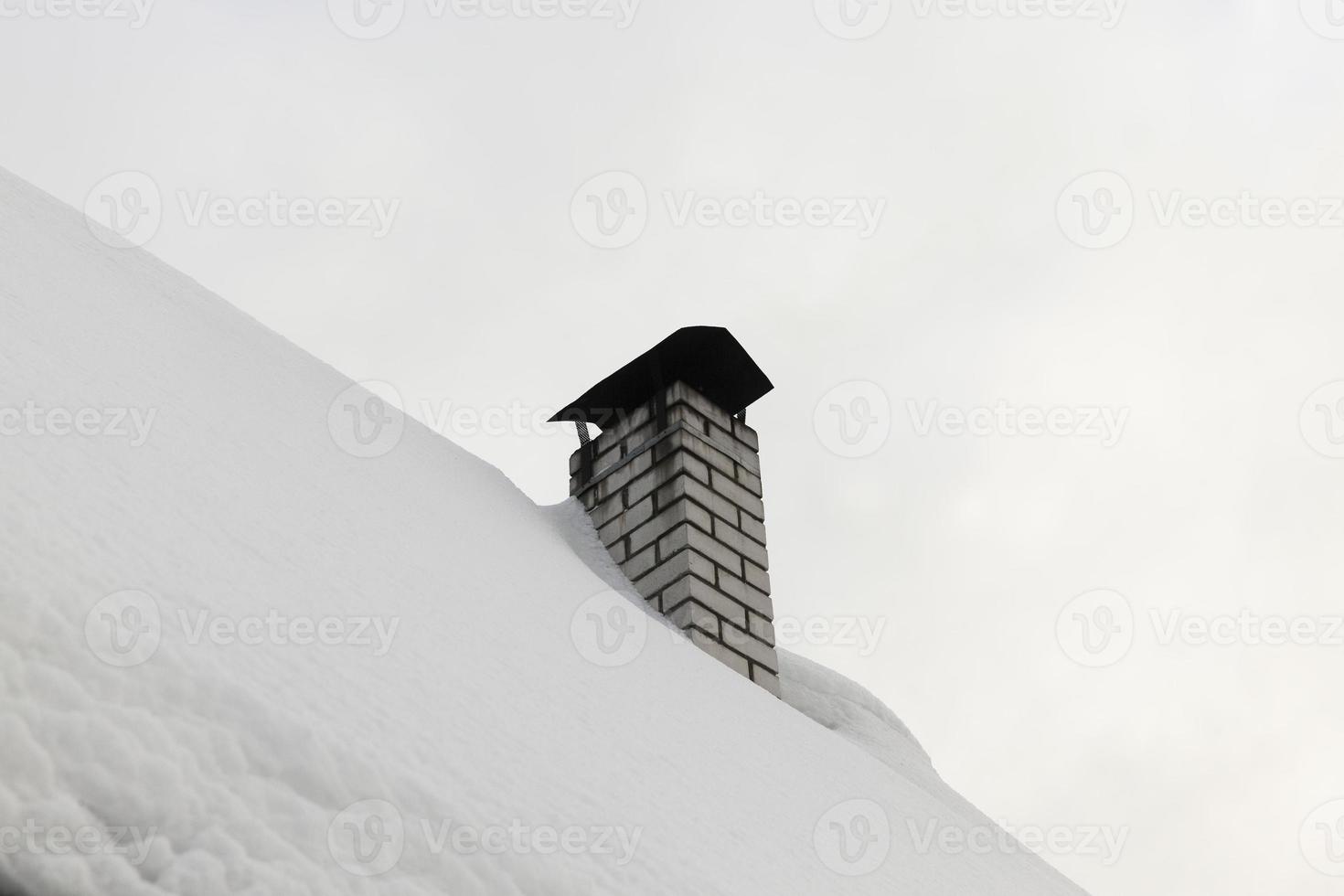 skorstenar på taket av en byggnad på vintern foto