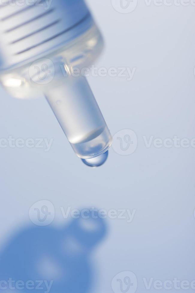 makrobild av en spruta med droppe. spruta makrovy i blått. foto
