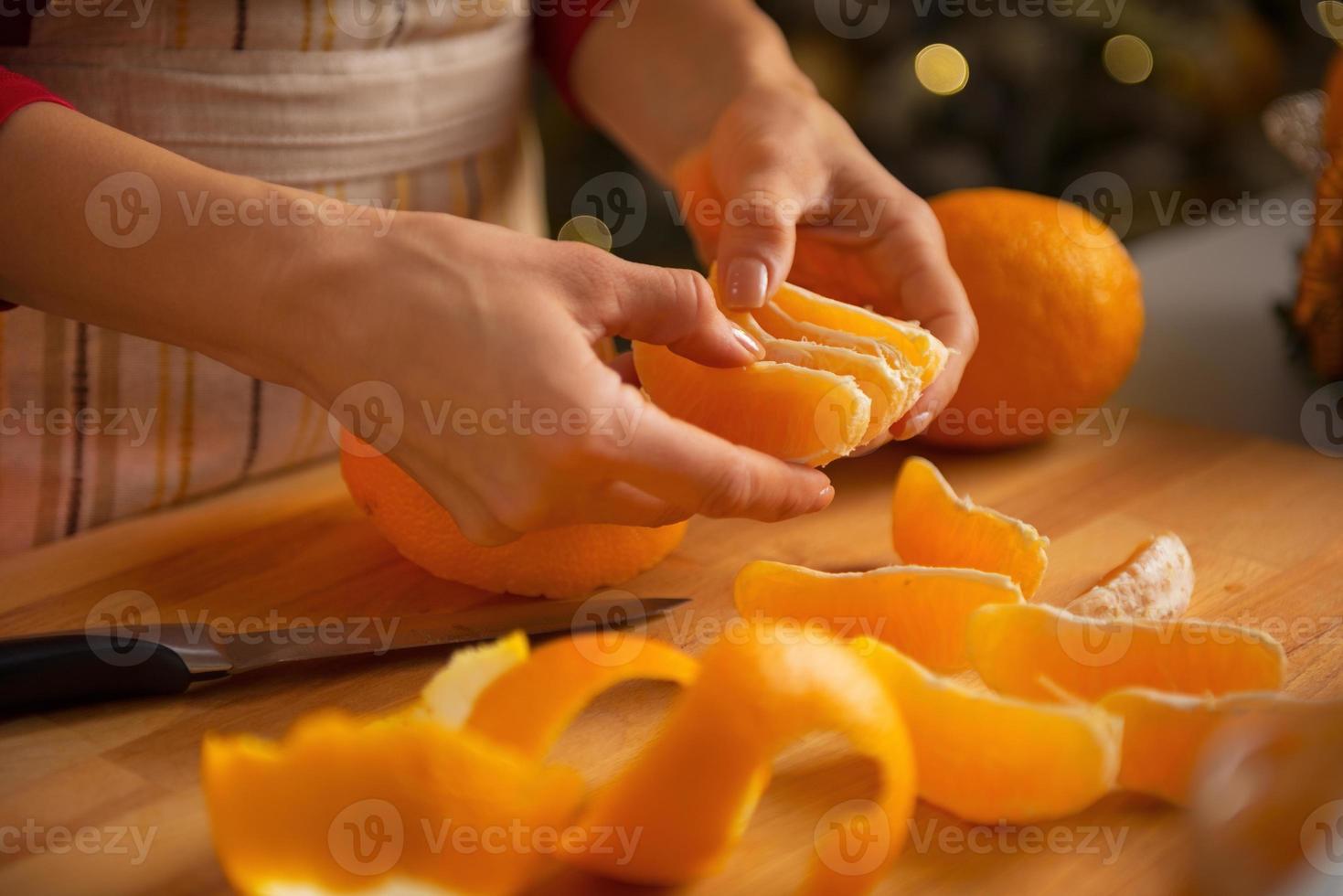 närbild på ung hemmafru som delar orange skivor foto