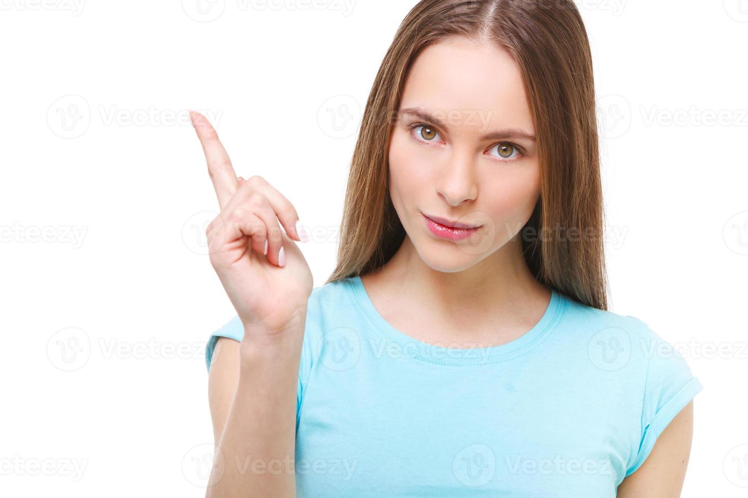 ung kvinna som pekar med fingret på isolerat kopieringsutrymme. foto