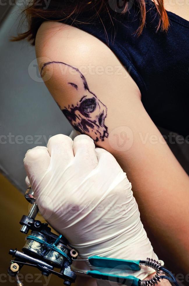 process för att göra tatuering på en flickas axel foto