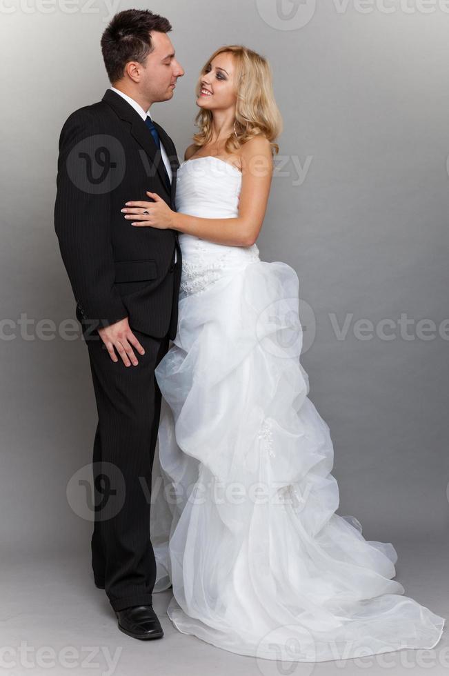 lyckliga gift brud brudgummen på grå bakgrund foto