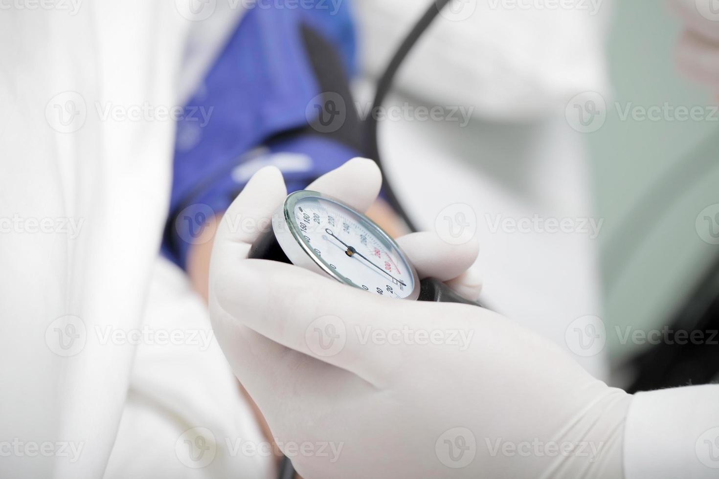 läkare som mäter patientens blodtryck foto