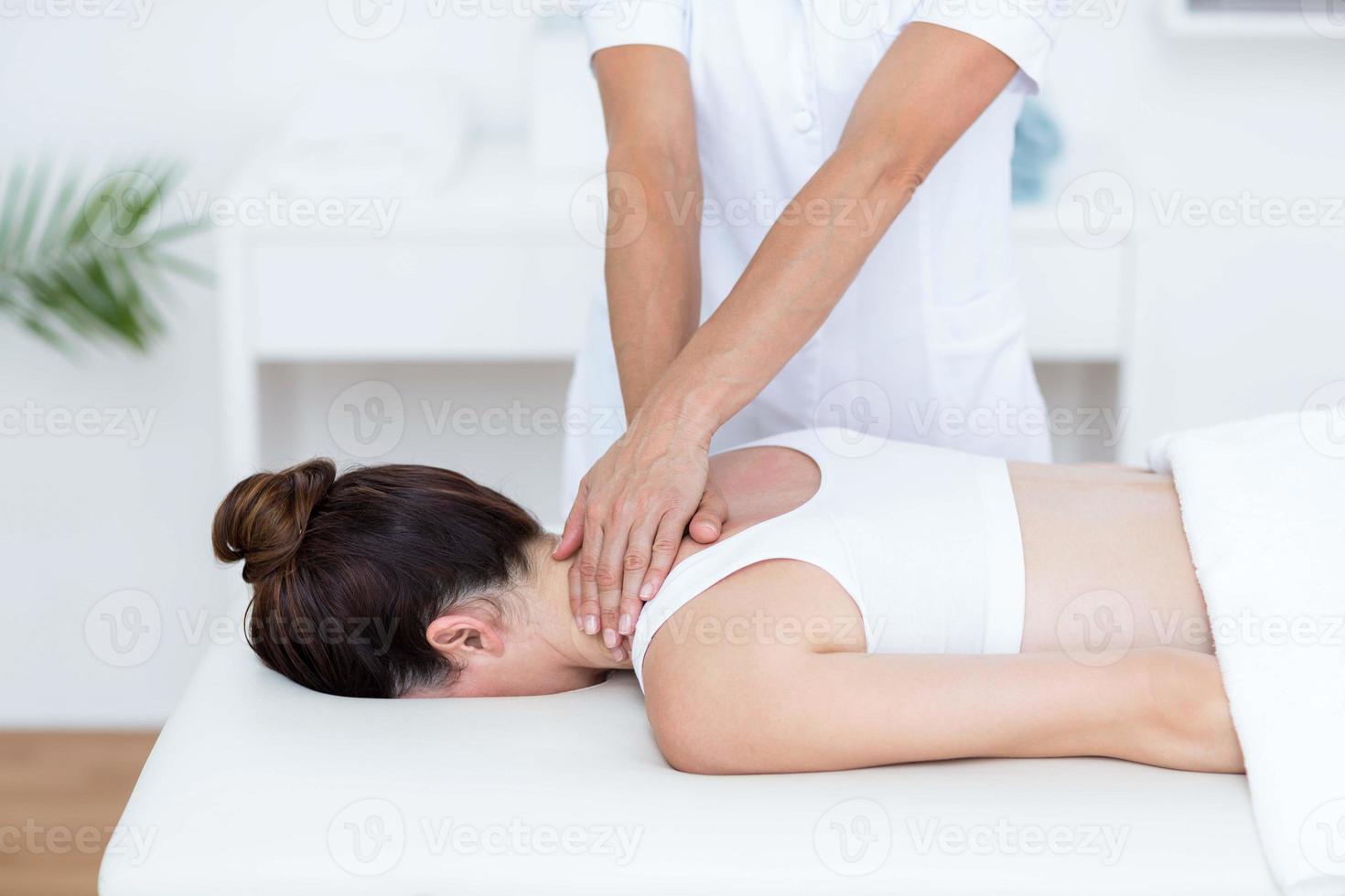fysioterapeut som gör nackmassage foto