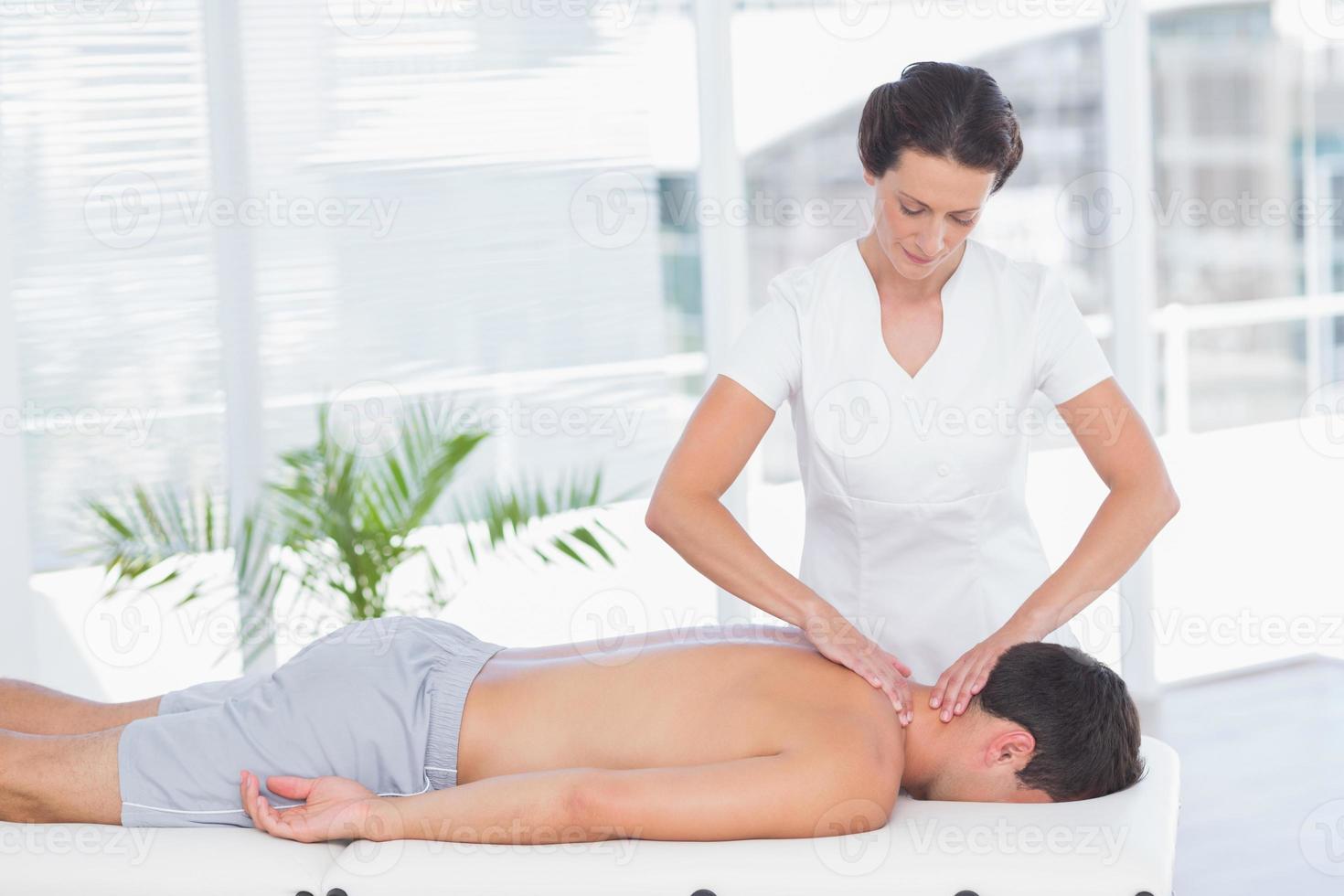 fysioterapeut som gör nackmassage till sin patient foto
