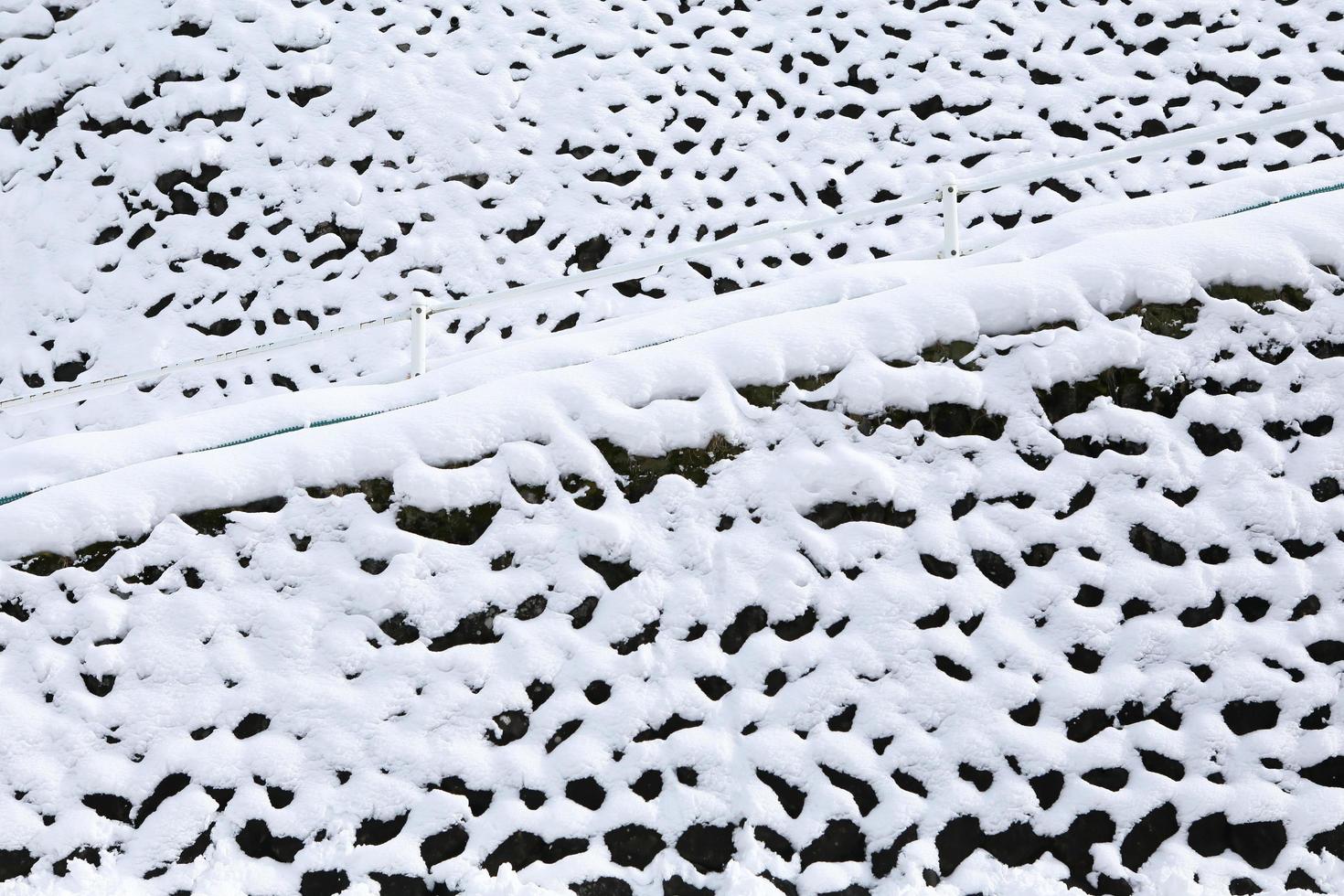stenmur täckt med snö i foto