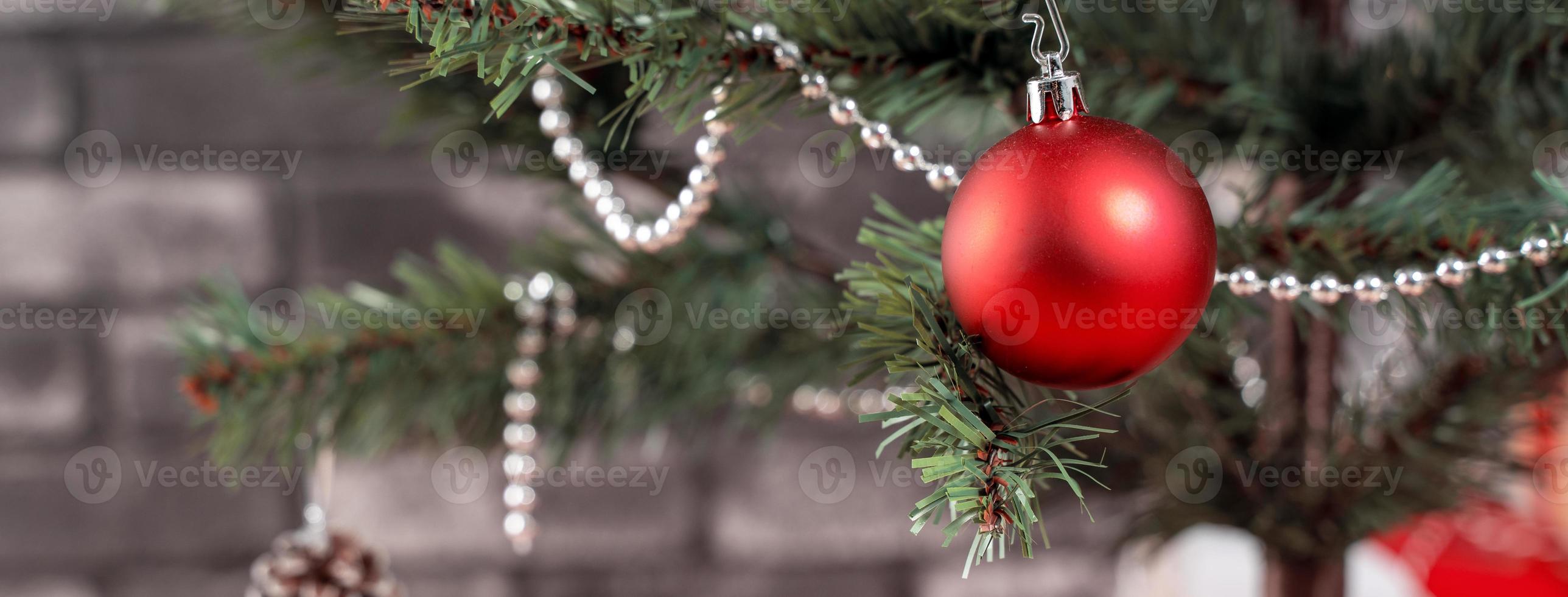 dekorerad julgran med inslagna vackra röda och vita presenter hemma med svart tegelvägg, festligt designkoncept, närbild. foto
