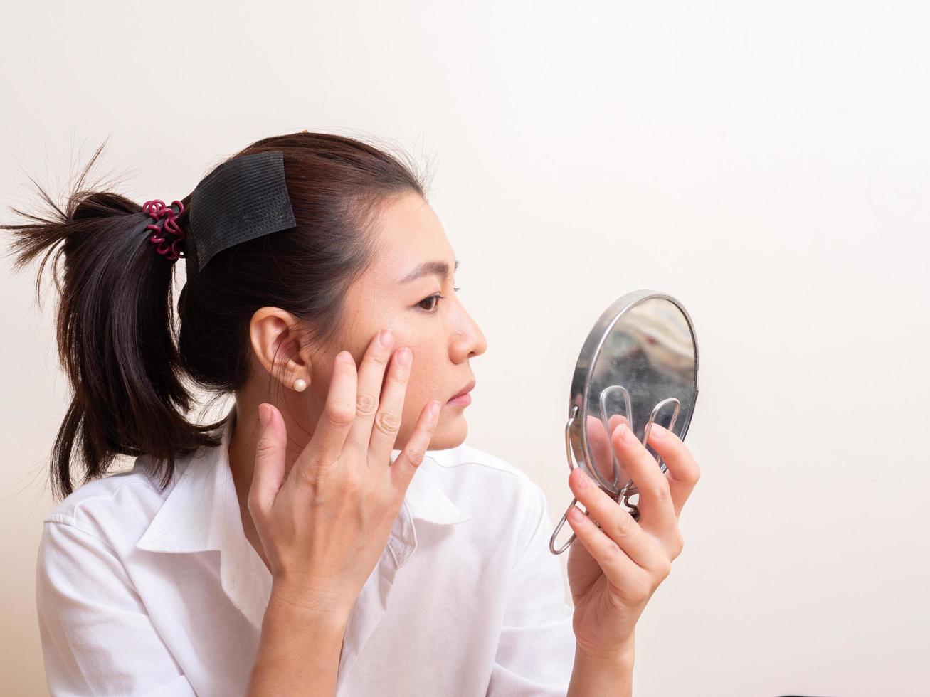 ung kvinna som applicerar make-up på ansikte foto