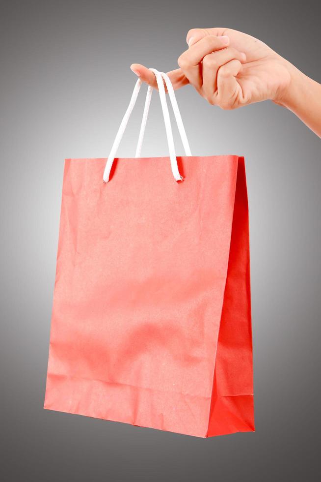 kvinnlig hand som håller röd väska - shopping och semester koncept foto