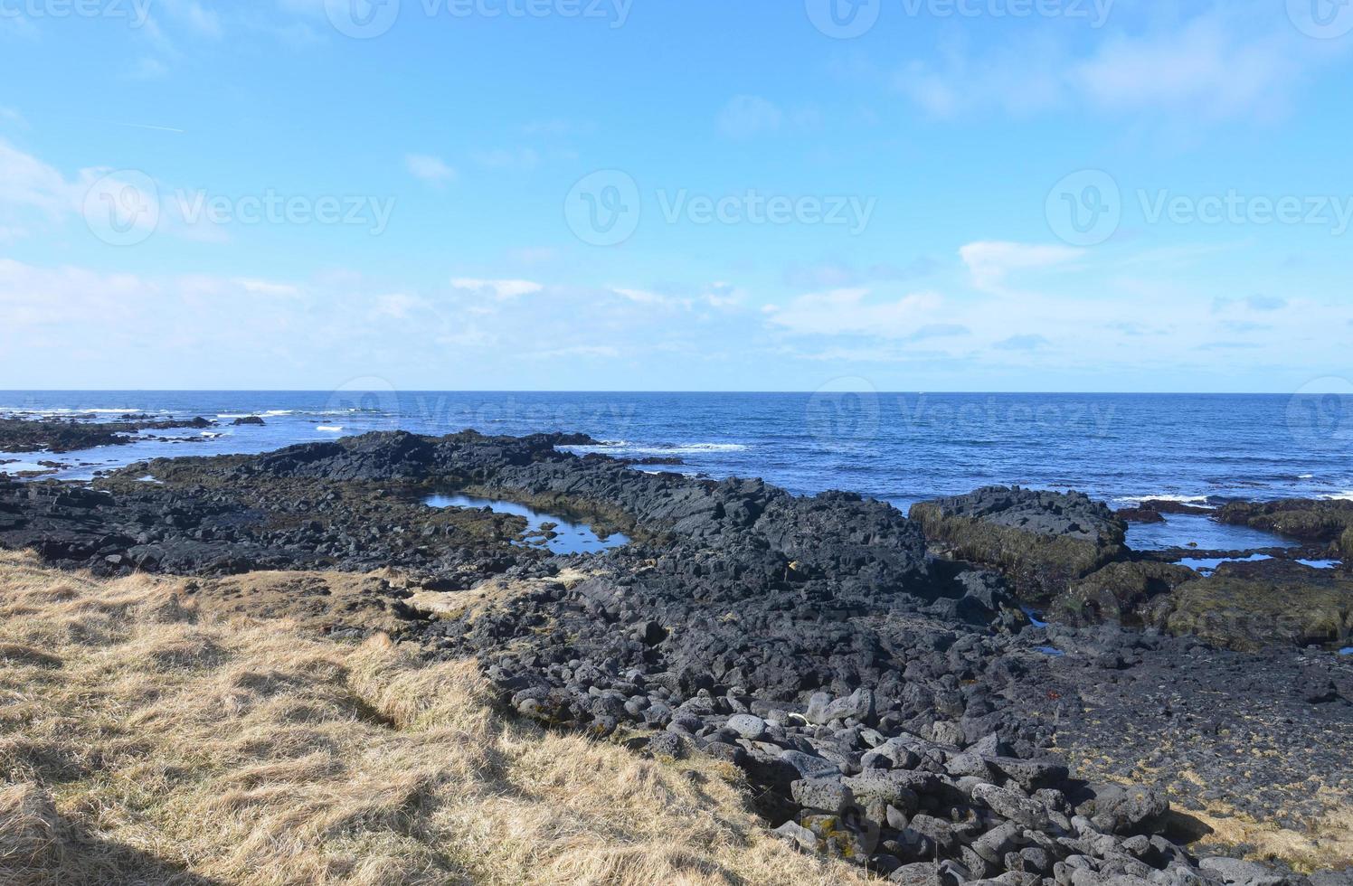 strandlinje havslandskap med blått hav och lavasten foto