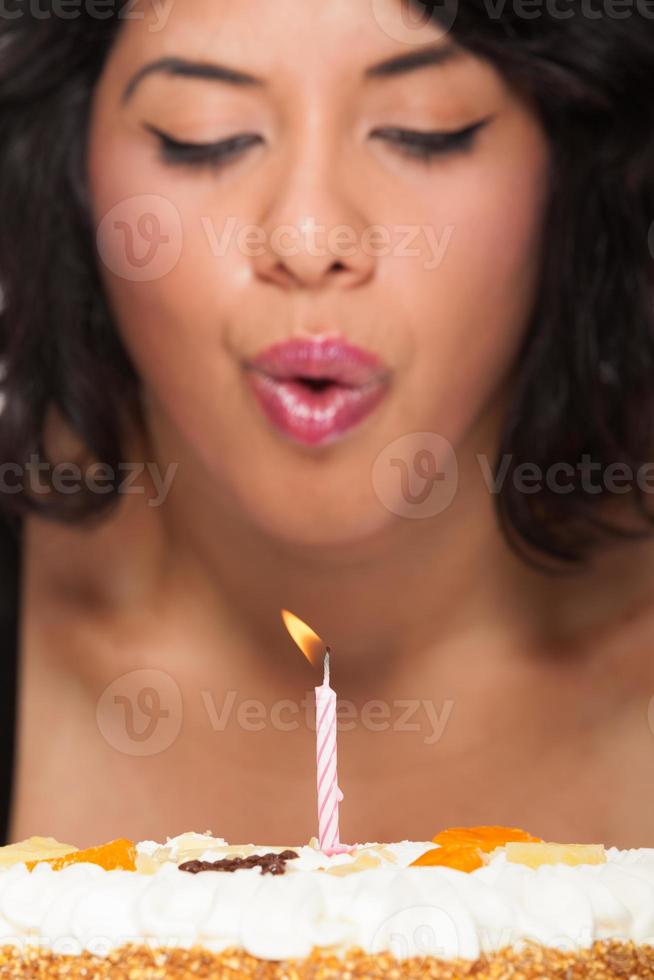 ung kvinna blåser ut födelsedagstårta ljus foto