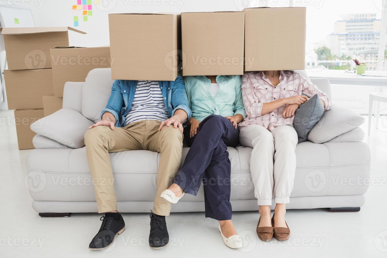 kollegor som sitter på soffan som täcker med kartong foto