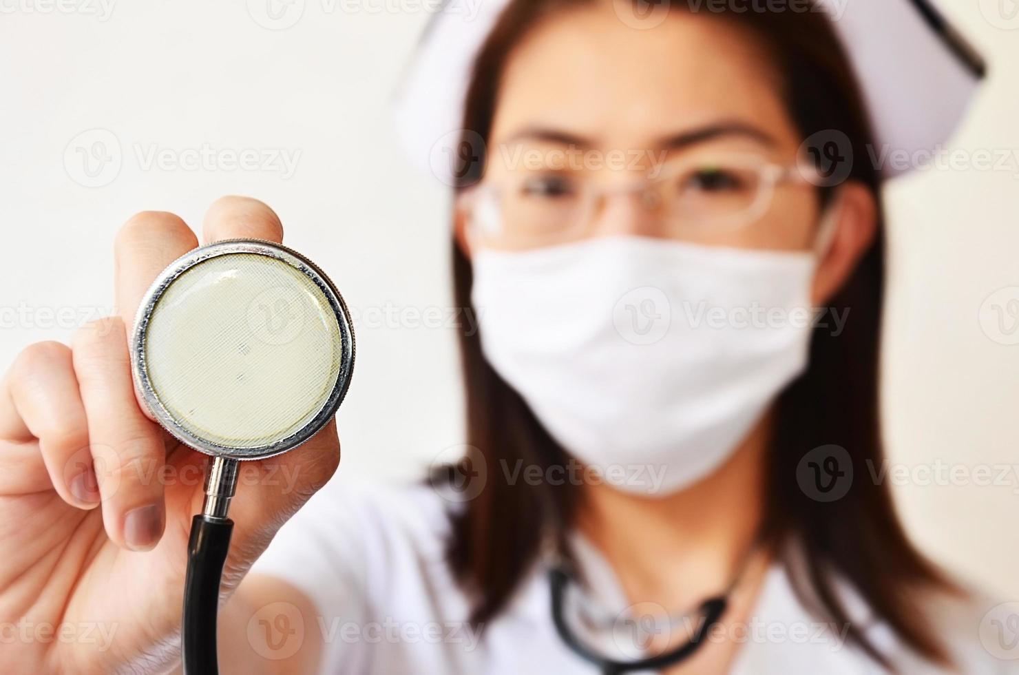 sjuksköterska i ansiktsmask med stetoskop foto