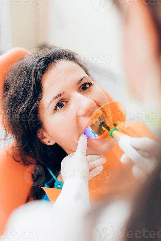 professionell tandverktyg kirurg använder UV-lampa foto
