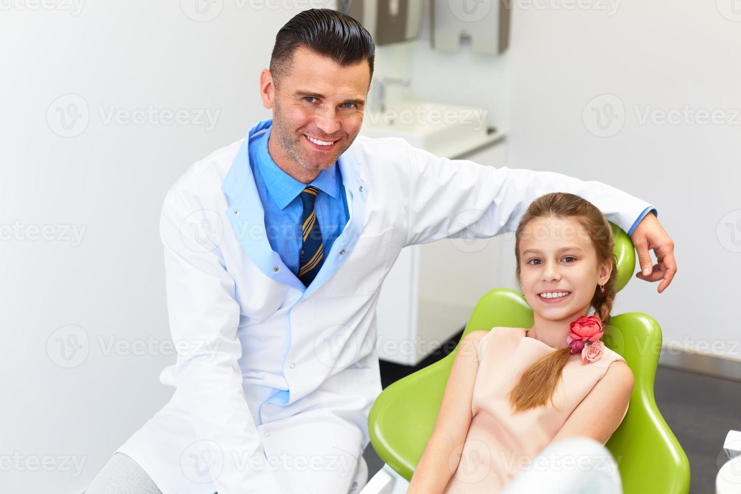 tandläkare som undersöker små flickors tänder i tandläkerstolen foto