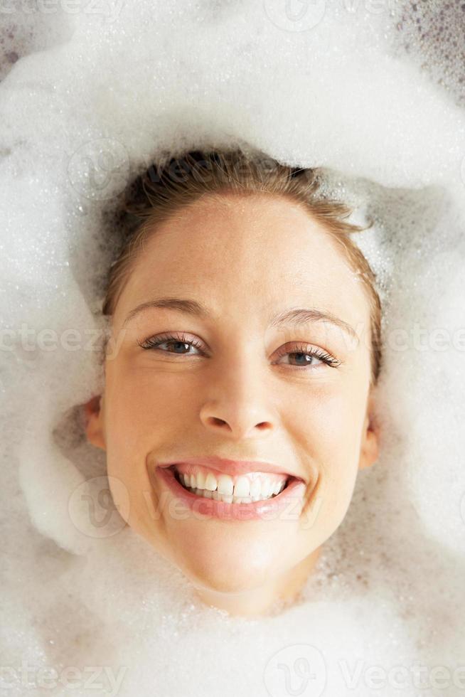 kvinna avkopplande i bubbelfylld bad foto