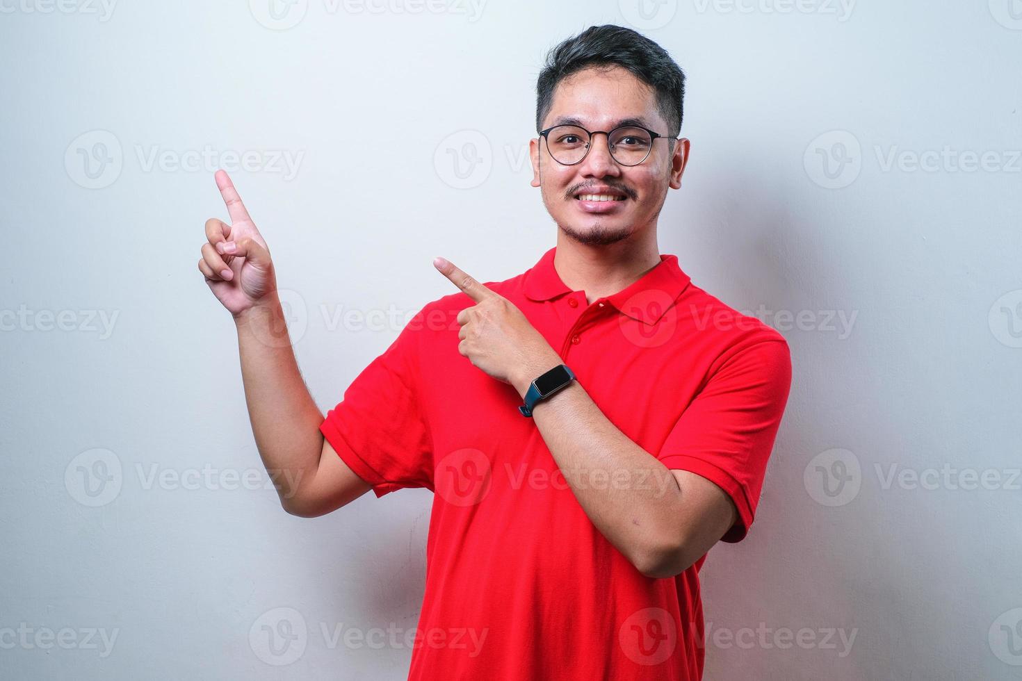 ung stilig asiatisk man klädd i casual skjorta pekar något på hans sida med båda händerna foto