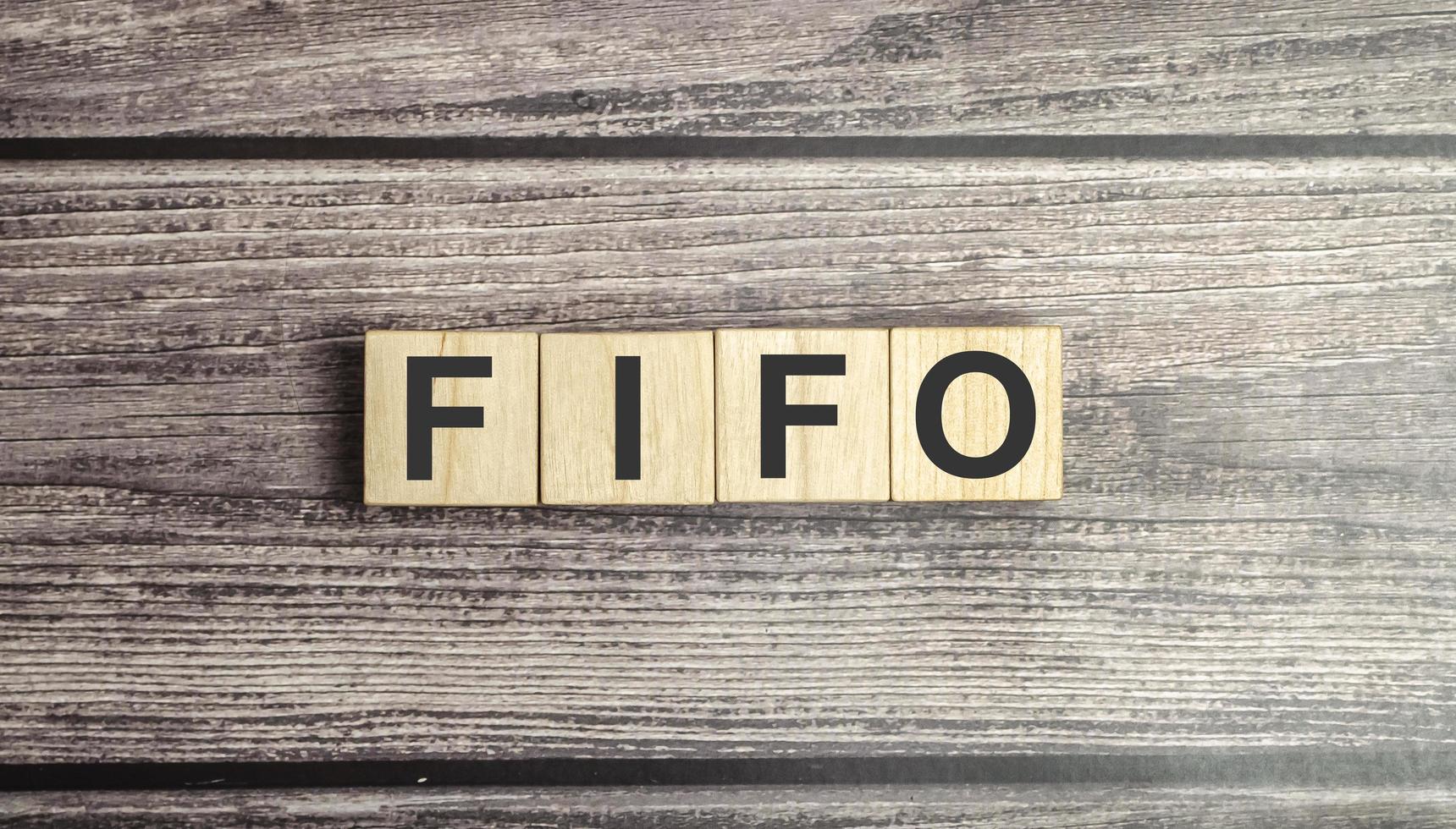 fifo först in och ut symbol. konceptord fifo först in först ut på träklossar. foto