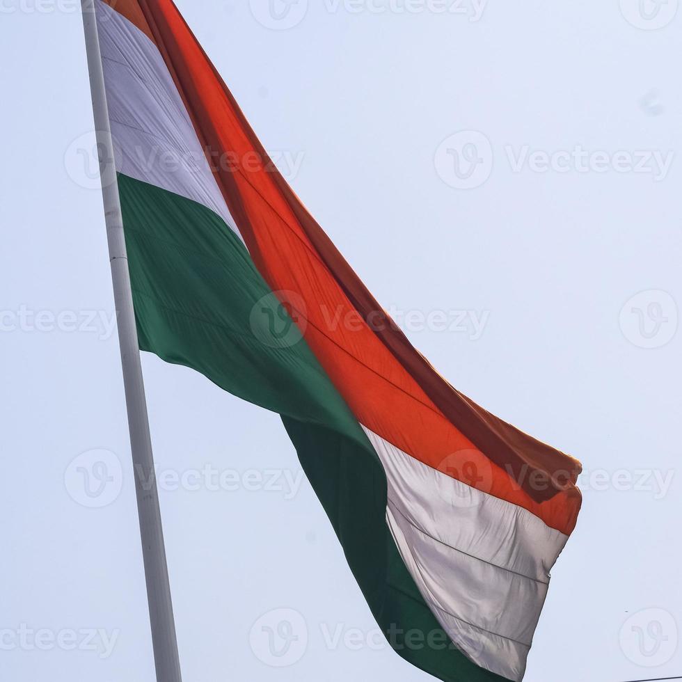 Indien flagga vajar högt på connaught plats med stolthet över blå himmel, Indien flagga vajar, indisk flagga på självständighetsdagen och republikens dag i Indien, tilt up shot, viftande indiska flaggan, flaggor i Indien foto