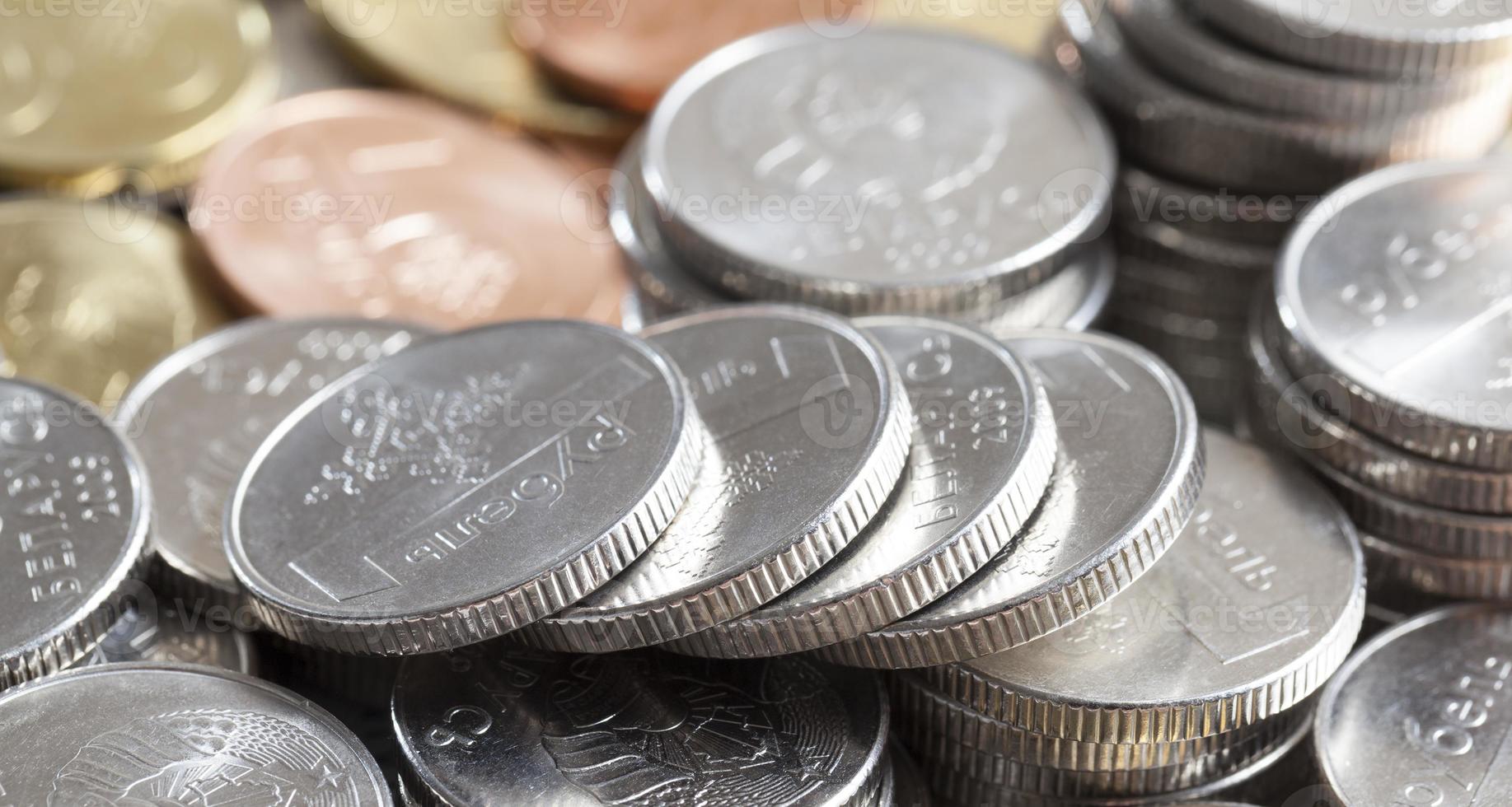 silverfärg på vitryska mynt, staplade i en hög, i bakgrunden en annan färg på mynt foto