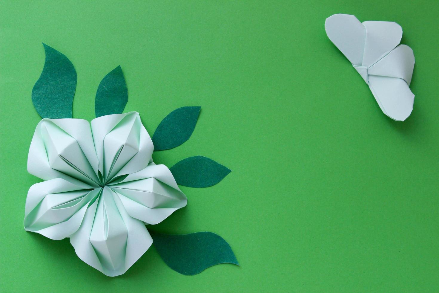 origami papper bakgrund med fjäril, blomma och blad. med plats för text. origami sammansättning. pappershantverk foto