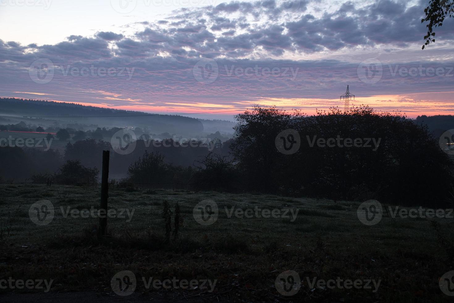 stigande sol på dimmig äng på morgonen i saarland foto