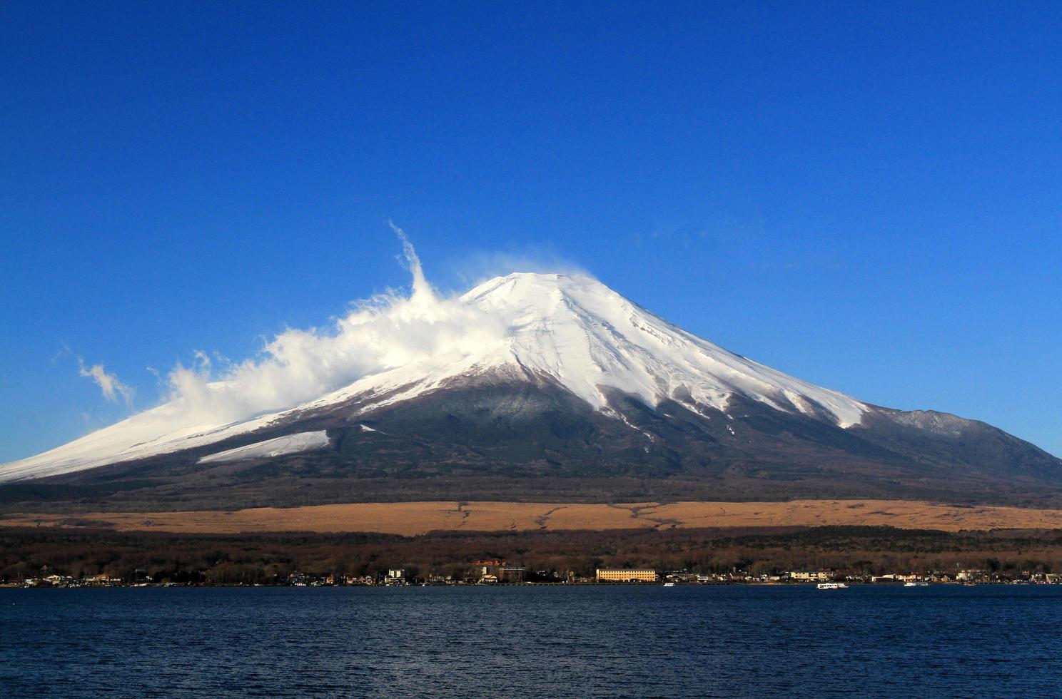 Fuji berg med snö och dimma täckt topp och klarblå himmel bakgrund med ovan kopia utrymme. detta berg eller plats känd i Japan och Asien för människor som reser för att besöka och ta bilder. naturlig foto