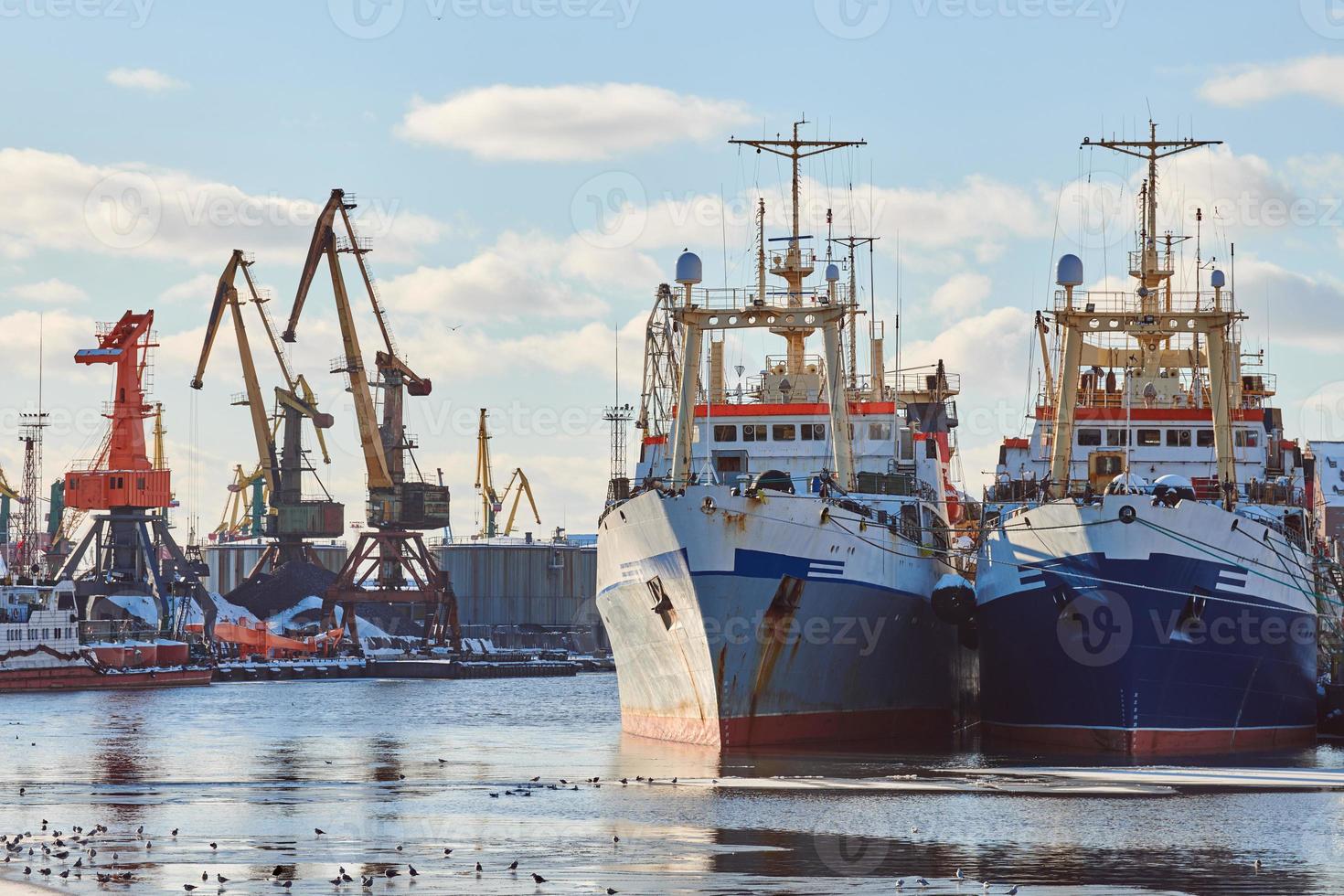 förtöjda fartyg och hamnkranar i hamn foto