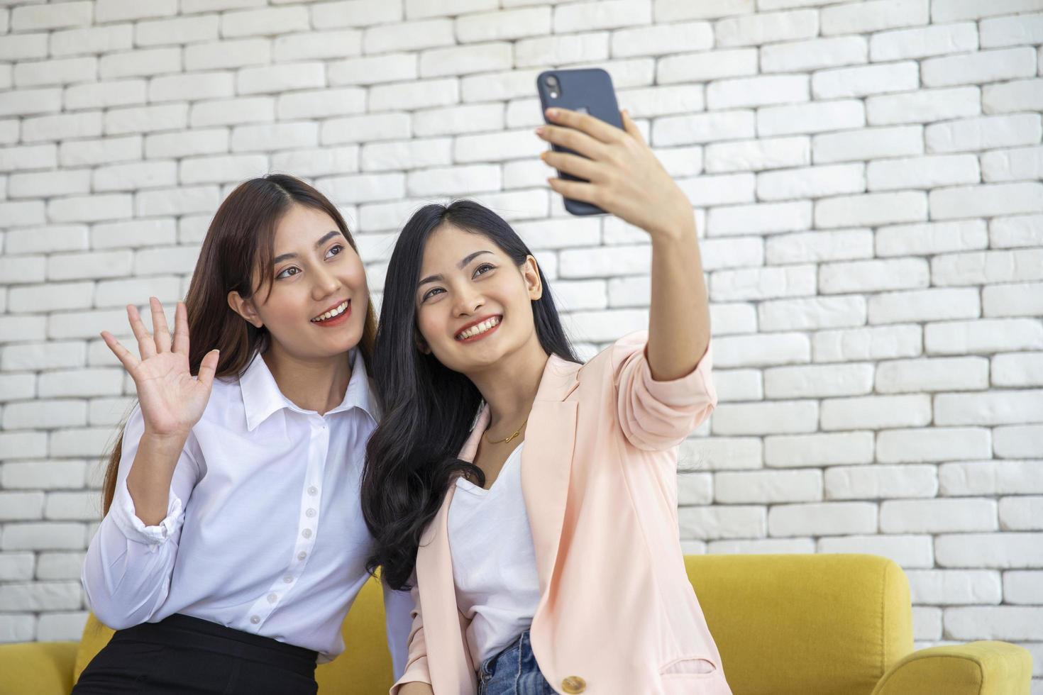 glad vacker ung asiatisk kvinna vänskap selfie tillsammans, lycka tonåringar tar bilder selfie i vardagsrummet foto